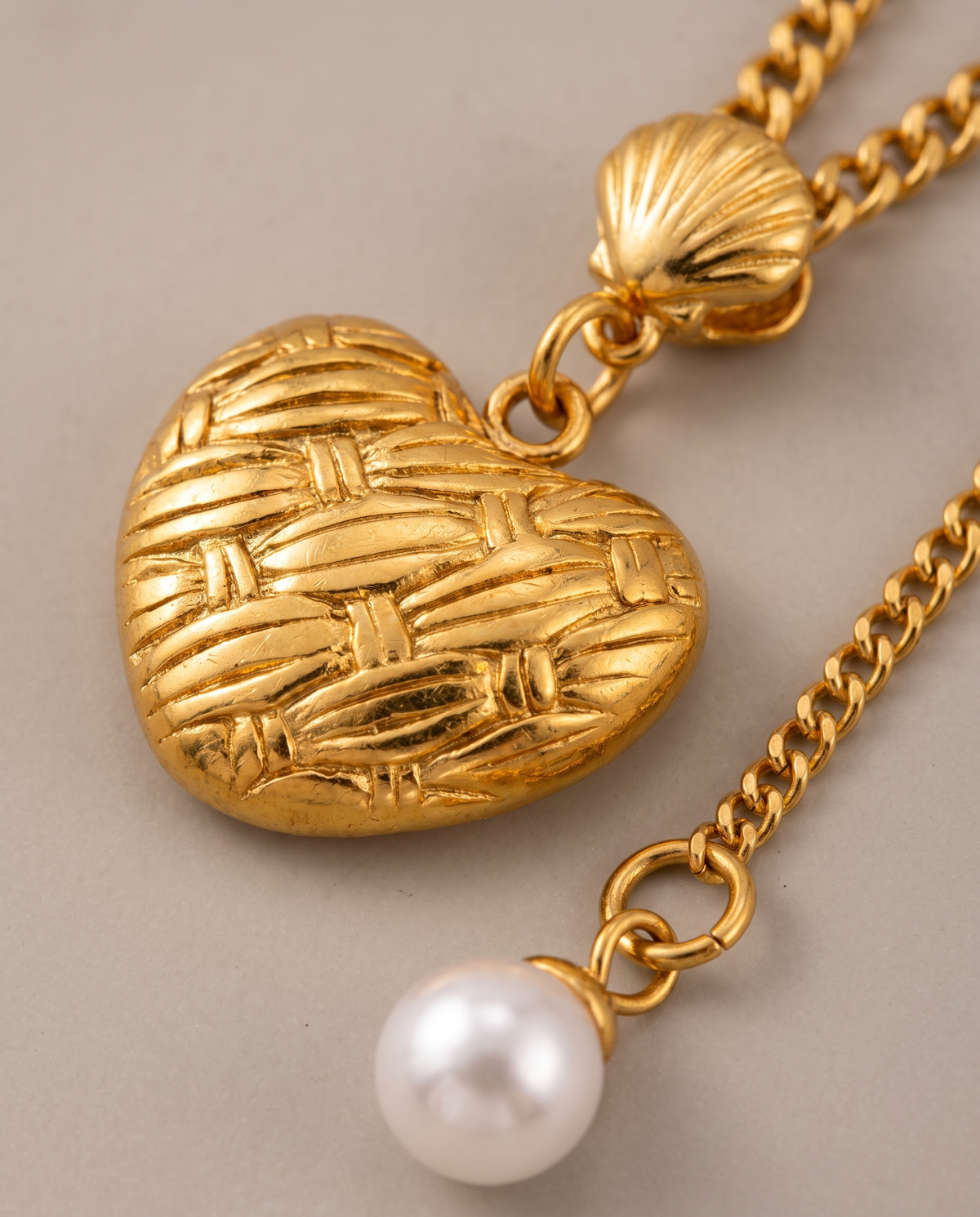 Love Pendant Tassel Necklace in gold — stainless steel with 18K gold plating, on a plain ground, view 3.