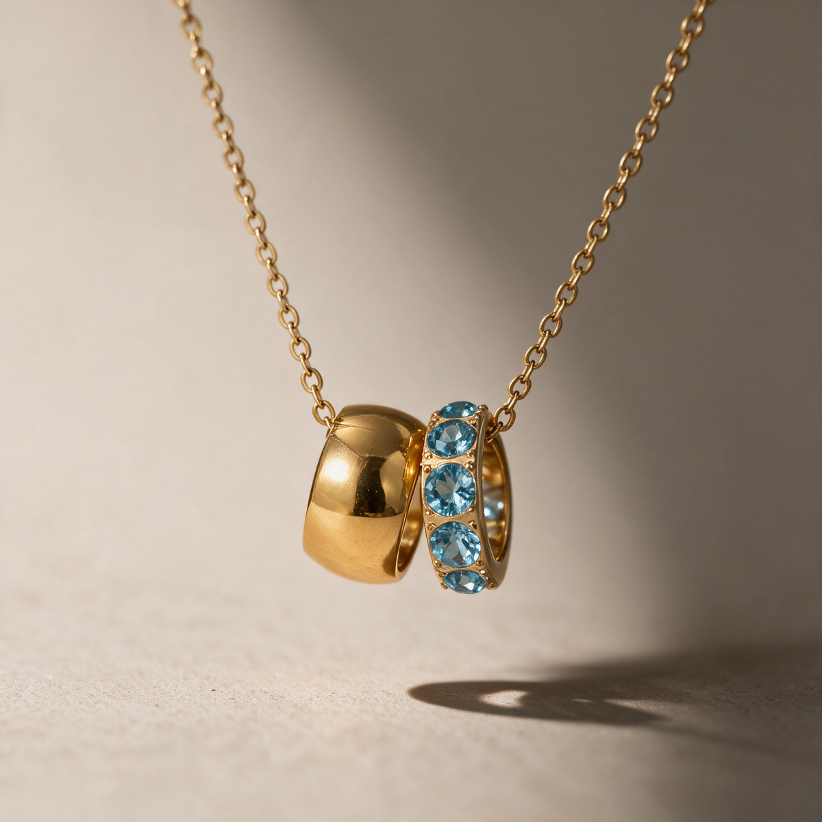 The Linked Birthstone Necklace in blue, styled in natural light.