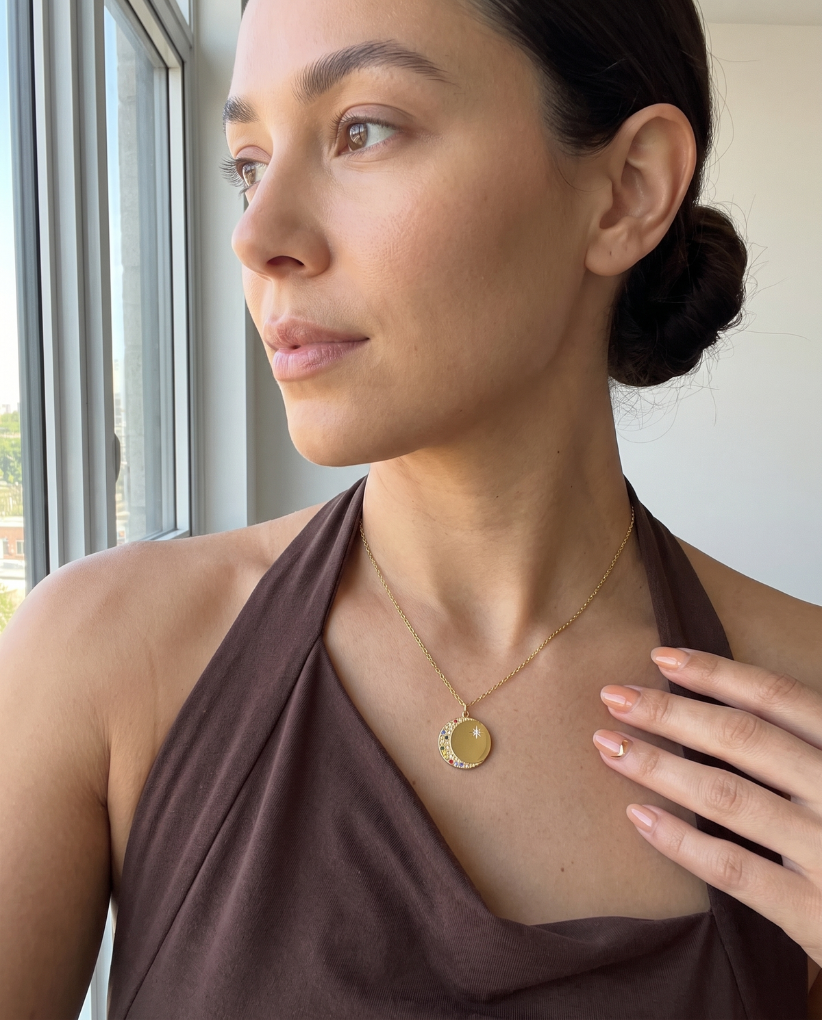 Oval Diamond Drop Necklace — a hand turning the pendant.